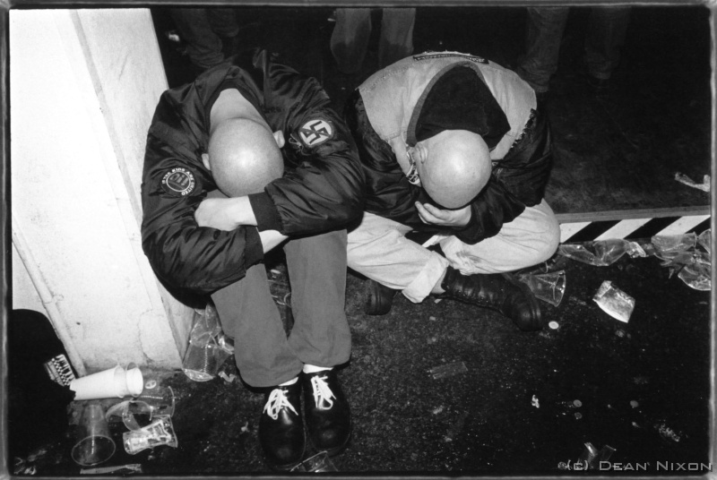 2001.04 Leipzig. Ska Anti-Fa Party_hf <div  align=left>April 2001<br>Dear PMrs, <br>The history of the fascists here still weighs heavy, and recently attention has been focused on them again as the numbers and problems with neo-nazis are apparently on the rise. Although the phenomenon of far-right cultures is by no means limited to Germany, the emergence of a hard-core far-left movement also seems to be gaining momentum and attention. This group, which some say are more of a worry, identifies itself by loudly and visibly opposing the neo-nazis. This picture was taken at an "Anti-fascist Ska Concert" (ear-splitting hard, fast and heavy punk reggae blues mix), and at first glance they dont look any different, but the slogans they wear declare vehemently their stance. <br>On the subject of violence..."to shoot or not to shoot?". That was the question as I boarded a tram late one night and noticed, 2 metres from the door, a man slamming another against the side of the tram and pressing a knife into his cheek...I drew my trusty Mju from my jacket pocket, sliding the cover back, and then asked myself where my escape route was...actually there was nowhere to go. I looked at the driver, and really doubted he would understand to slam the door shut behind me after I took the shot...he would have (in that special German way) asked to see my ticket as I got the knife in my back. The few bucks the picture would have made were of course not worth it. (By the way, dont worry about the bad guy and his victim...they were dealers arguing about who should have paid for the latest shipment!) <br>Hey, its really Spring here now. <br>Cheers all, <br>Dean<br>