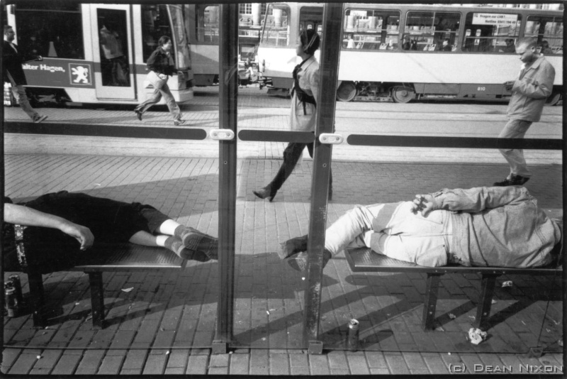 2002.07 Drunks Sleeping. Leipzig_hf <div  align=left>July 2002<br>Dear All,<br>"From where I sit"...outside, in a crowded cafe street in the centre of Leipzig late on a warm Summer afternoon...appetizing smell wafting by, an Oasis CD sometimes breaking through the murmuring crowds, the waitress brings me the usual thin, tepid coffee - dumping it on my copy of The Guardian. <br>A beautiful girl with a tattooed back sits opposite with a not-now uncommonly Beckham-friseured boy, an old man makes his way between the tables trying to sell a street magazine, tourists take photos, couples with their full shopping bags stop for pasta and wine or beer. <br>Wait here long enough and someone you know will pass by or stop, and later every table and chair will be occupied until 1 or 2a.m. - business deals will be sewn up and students will discuss their theses, lovers will fawn or fall out while others will eye each other and start something new. The 3 already tequilered girls on my left pour over photos from their ballet school and the 2 men on my right reminisce about why "it was better" in the days of the GDR. <br>Vicki, a young model, stops to proudly show me her newly braided hair, as the last of the sunlight glances suddenly through the thunderstorm-threatening clouds filling the narrow passage with a warm glow, while somewhere else world leaders plot the way to our annihilation - and Amy, my week old daughter, is sleeping. <br>Dean<br>